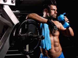 man at the gym drinking from the mixer